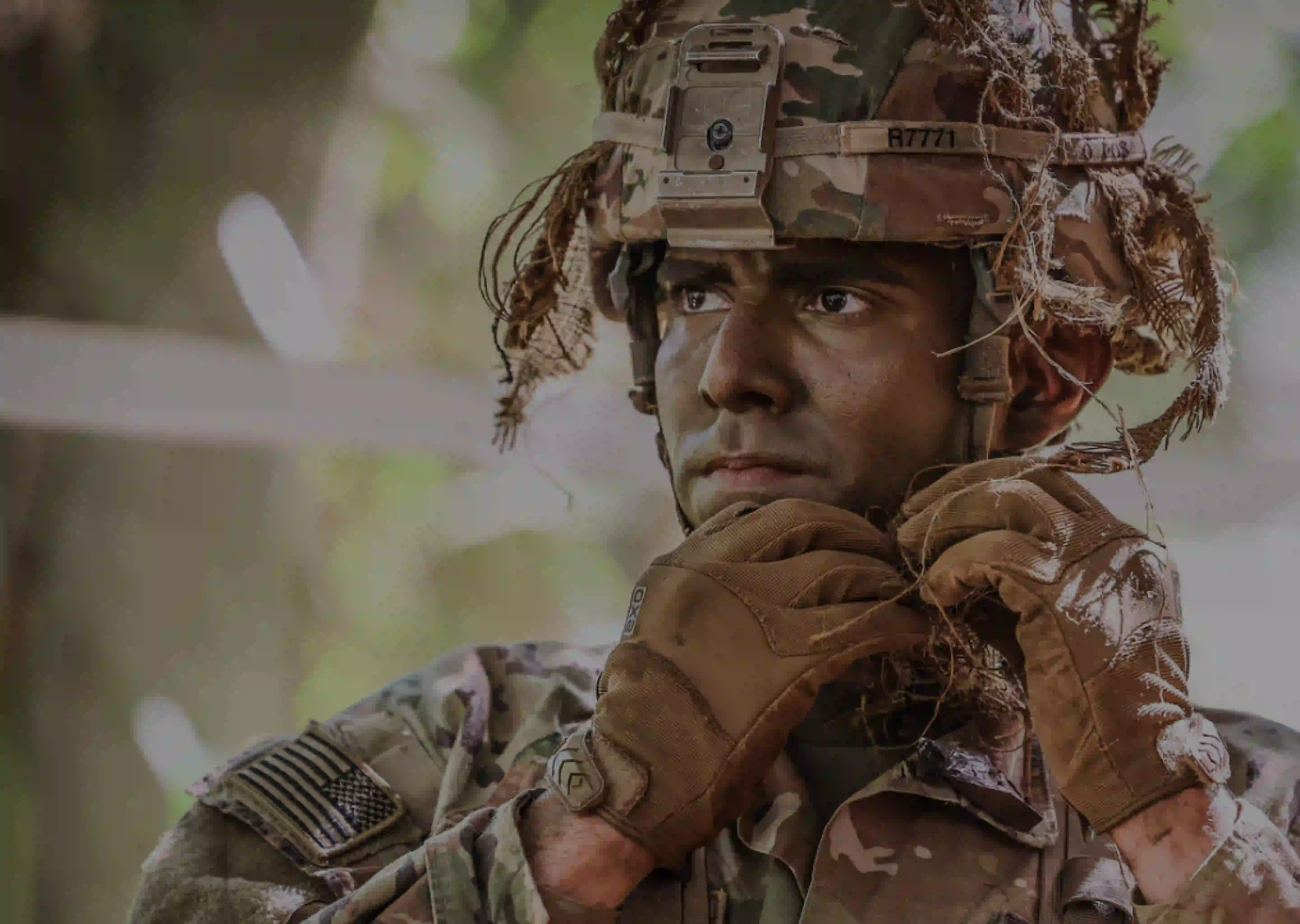 A male Soldier putting on a helmet